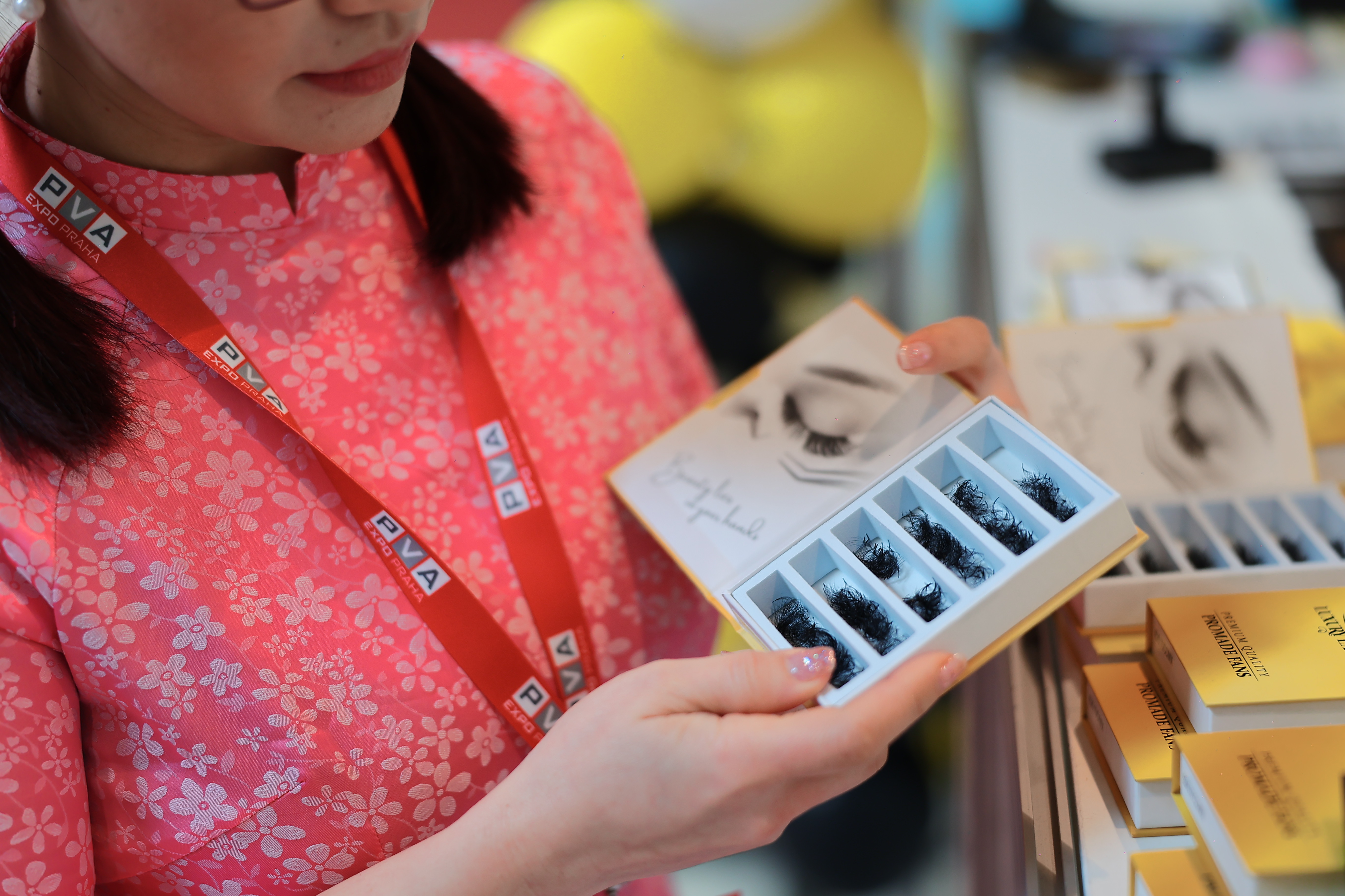 Detail ženy, která drží balení umělých řas.